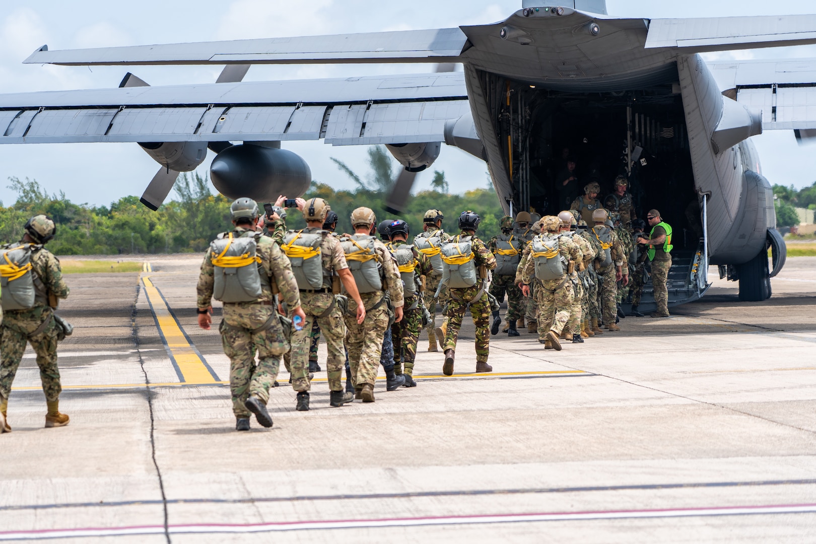 A group of soldiers boards a military aircraft.