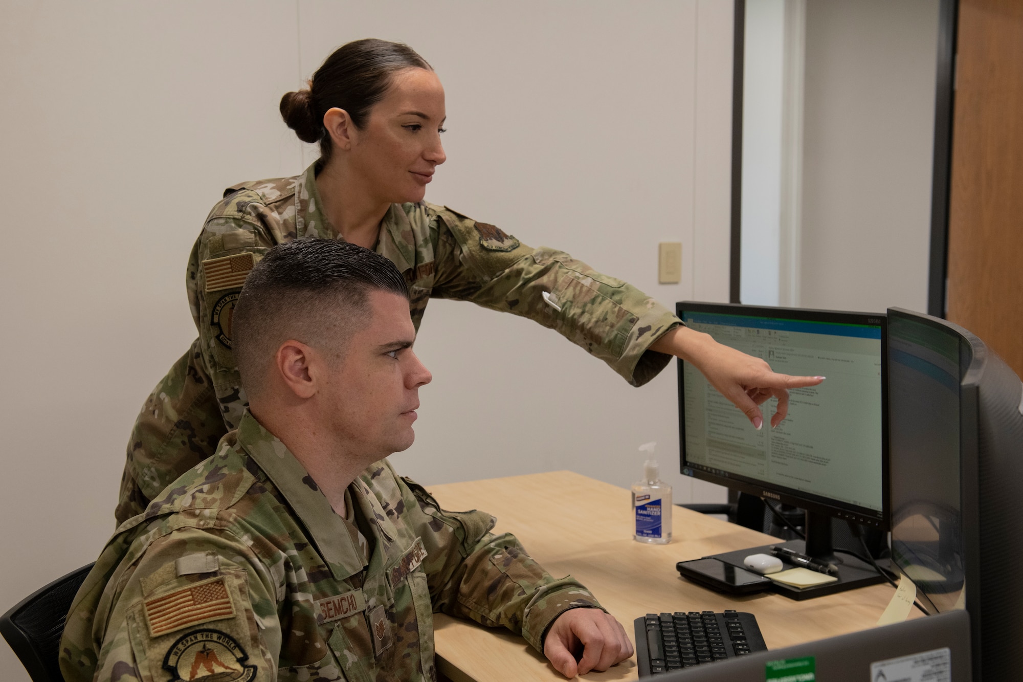 U.S. Air Force Tech. Sgt. Maria Cloherty, 325th Logistics Readiness Squadron unit deployment manager, back, shows Tech. Sgt. Robert Semcho, 325th LRS UDM, a feature on the Commander Toolkit, a web-based program used to track unit readiness, at Tyndall Air Force Base, Florida, July 15, 2022. UDMs use the CC Toolkit to ensure their unit is deployment ready, including annual training, medical appointments and physical fitness assessments. (U.S. Air Force photo by Staff Sgt. Cheyenne Lewis)
