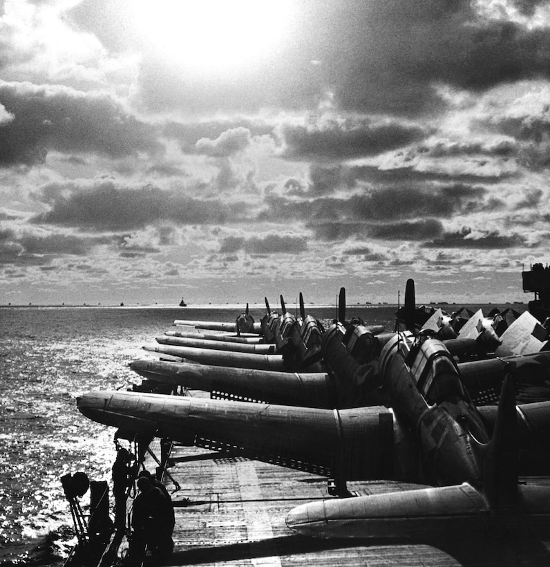 Navy warplanes (five Douglas SBD Dauntless bombers in foreground and one F4F-4 Grumman Wildcat at tip of deck) played major role in protecting armada during Operation Torch, November 1942 (Naval History and Heritage Command)