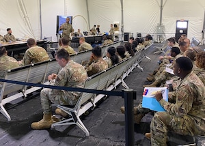 U.S. Air Force Tech. Sgt. Amos Gray, 325th Comptroller Squadron financial operations supervisor, receives a deployment briefing from Tech. Sgt. Micah Mincey, 325th CPTS unit deployment manager, at Tyndall Air Force Base, Florida, July 15, 2022. UDMs act as liaisons between various Air Force units and the individual service members tasked to deploy. (U.S. Air Force photo by Staff Sgt. Cheyenne Lewis)