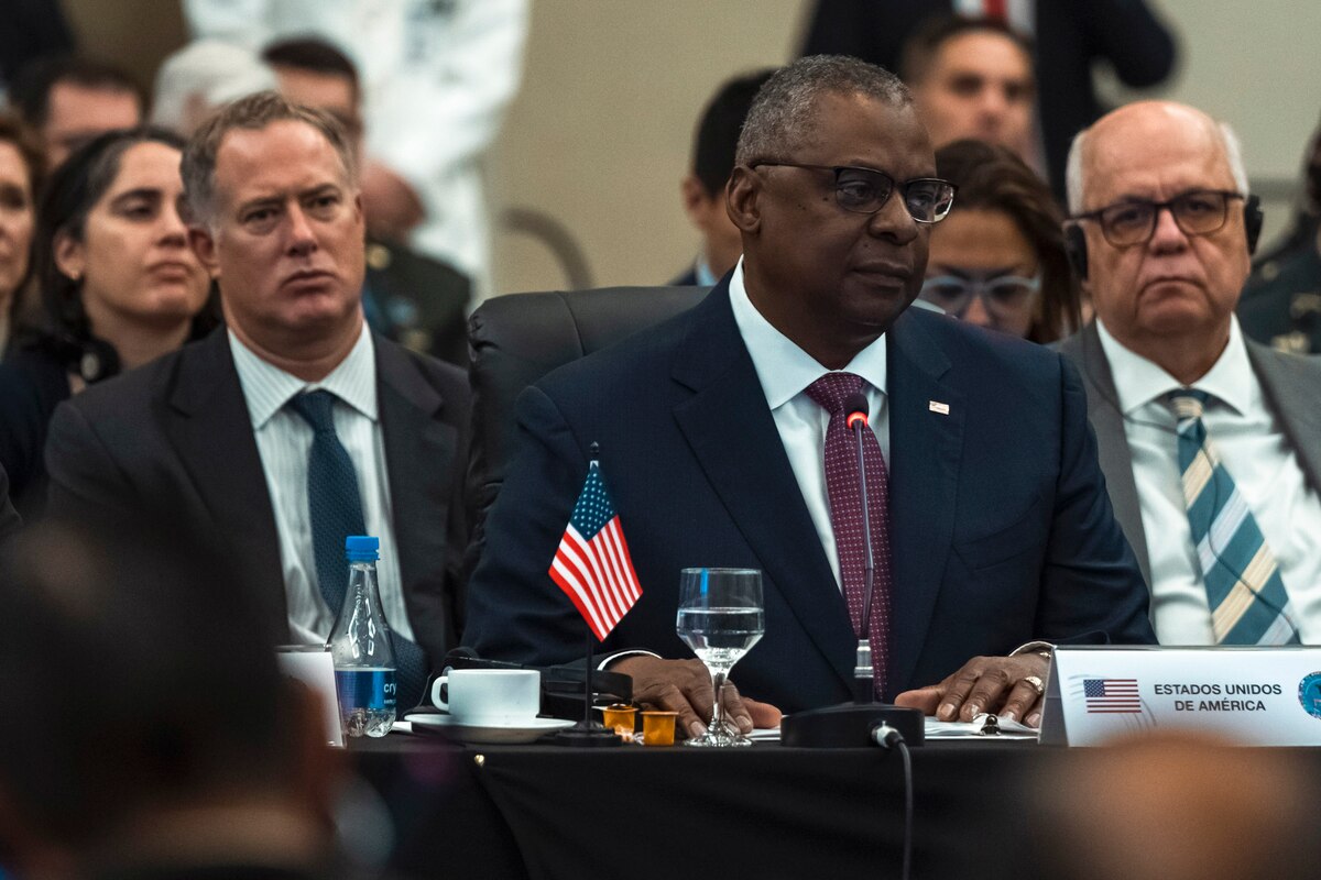 Secretary of Defense Lloyd. J. Austin III sits at a table with other officials.