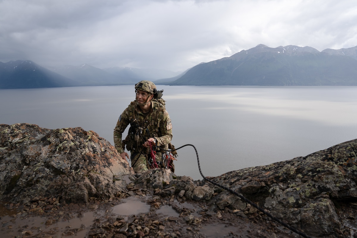 An Airman summits a cliff.