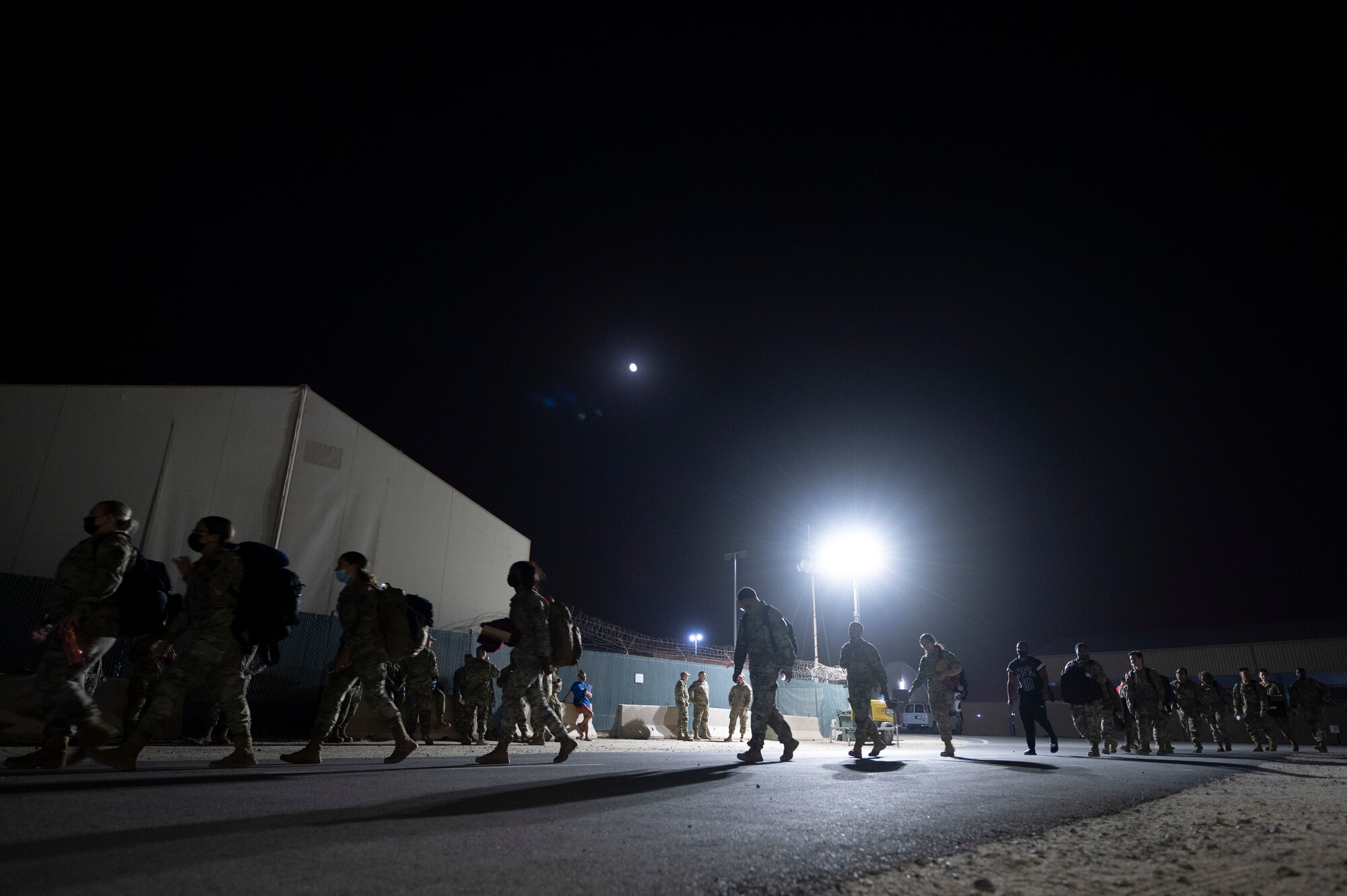 Airmen from the 386th Expeditionary Force Support Squadron Personnel Support for Contingency Operations team escort a group of Airmen inprocessing at Ali Al Salem Air Base, Kuwait, July 16, 2022. Hundreds of military personnel are inprocessed by the 386th EFSS PERSCO team each month, where they maintain accountability for each and every military member on the installation. (U.S. Air Force photo by Staff Sgt. Dalton Williams)