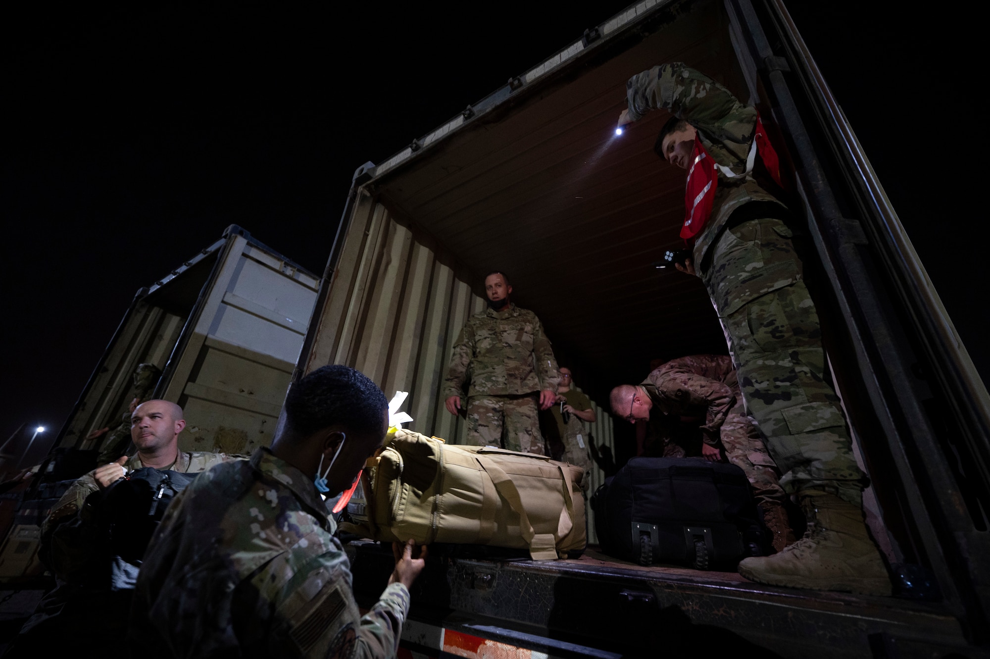 U.S. Air Force Staff Sgt. Darrin Deason, 386th Expeditionary Force Support Squadron Personnel Support for Contingency Operations customer support technician, assists inprocessing Airmen with unloading their luggage at Ali Al Salem Air Base, Kuwait, July 16, 2022. From rehearsing roles and responsibilities ahead of time, to coordinating with dozens of organizations on the installation, the 386th EFSS PERSCO team strive to make their inprocessing system as efficient as possible. (U.S. Air Force photo by Staff Sgt. Dalton Williams)