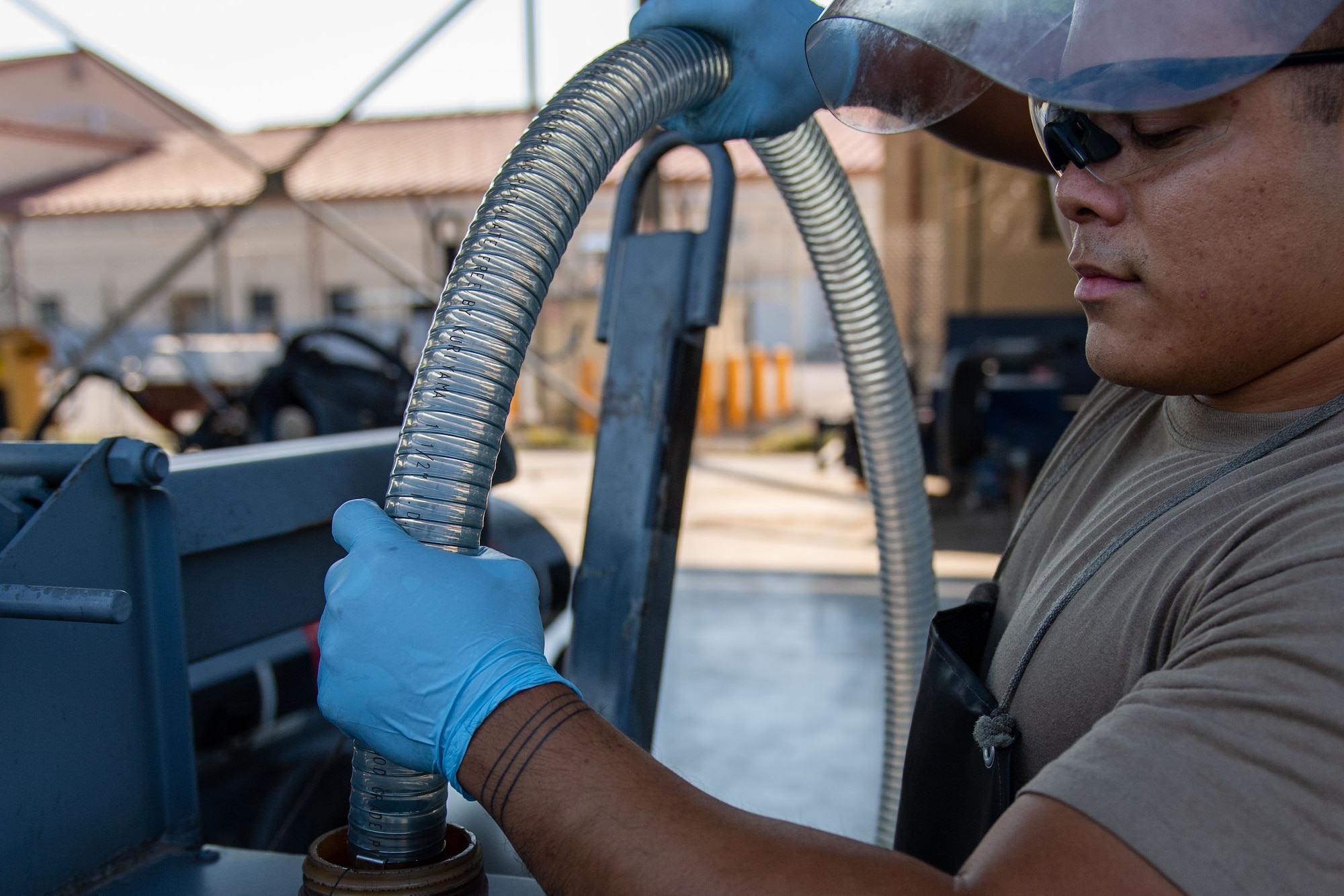 U.S. Air Force Senior Airman Shane Villegas, 31st Maintenance Squadron aerospace ground equipment (AGE) journeyman, attaches a pump hose to a fuel bowser to connect it to the AGE fuel polisher
