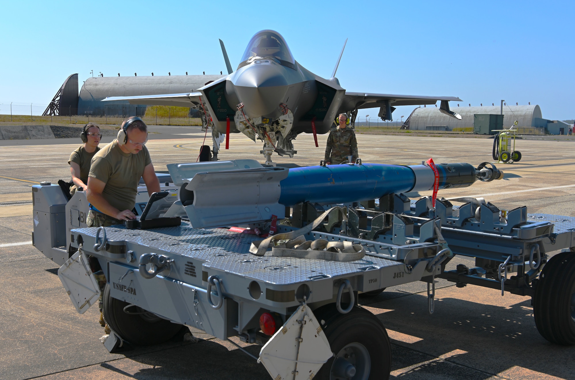 Airmen preparing to load missile onto jet