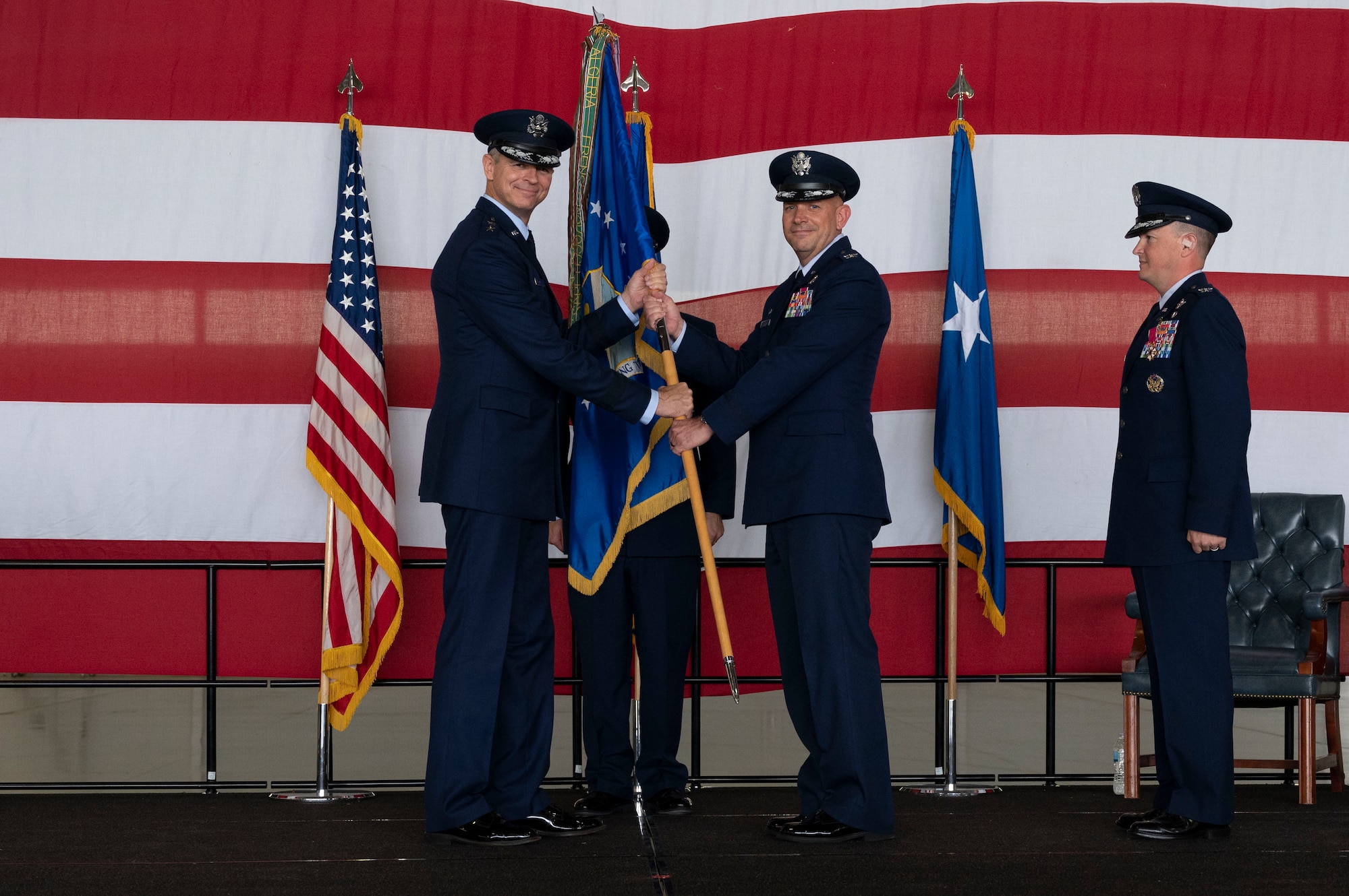 U.S. Air Force Col. Kevin Davidson accepts the 47th Flying Training Wing guidon from Maj. Gen. Craig Wills during the 47th Flying Training Wing change of command ceremony at Laughlin Air Force Base, Texas, July 22, 2022. The passing of the guidon to Davidson signifies the acceptance of command of the 47th Flying Training Wing. (U.S. Air Force photo by Airman 1st Class Kailee Reynolds)