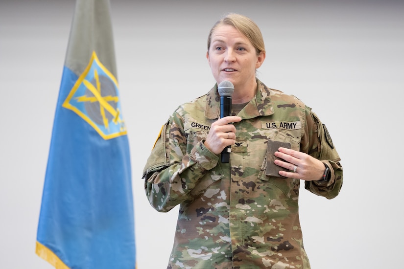 Soldier holds pocket sized bible on left side of chest while giving a speech.