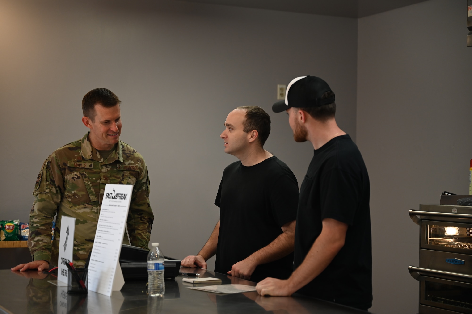 Pictured are three people talking.