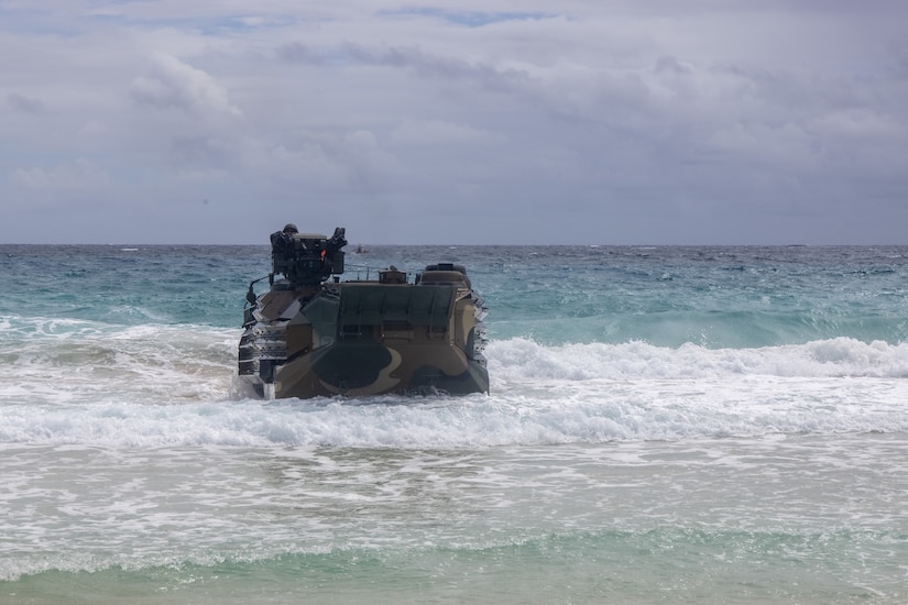 A maritime vessel exists the ocean and crawls up on the beach.