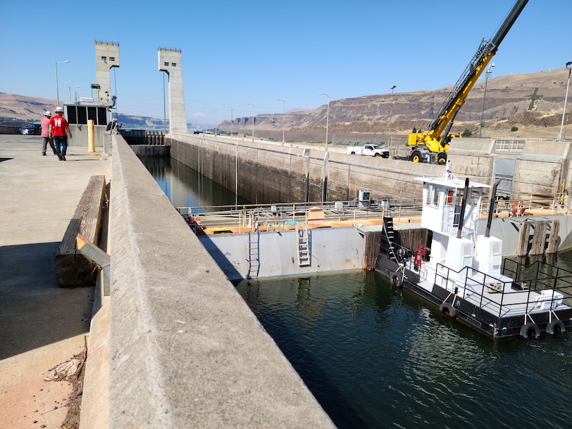 Brett Call (left), John Day Dam operations project manager, and Lee Kochis, power plant mechanic, look on as engineers with Portland District, U.S. Army Corps of Engineers, inspect the dam's upstream navigation lock gate, July 26.