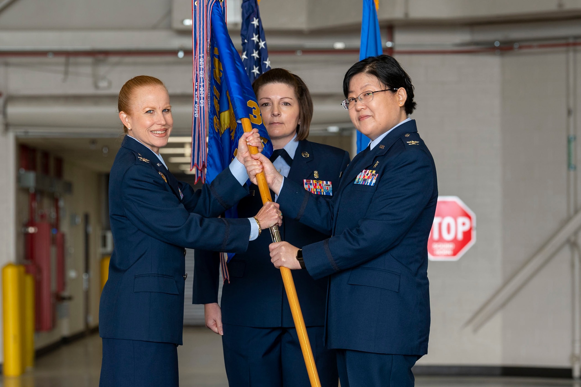 Col. Soo Sohn, right, accepts command of the 341st Medical Group from Col. Anita Feugate Opperman, 341st Missile Wing commander, during a change of command ceremony June 10, 2022, at Malmstrom Air Force Base, Mont. Guidon bearer Chief Master Sgt. Kristi Binard, 341st MDG senior enlisted leader, looks on. (U.S. Air Force photo by Airman 1st Class Elijah Van Zandt)
