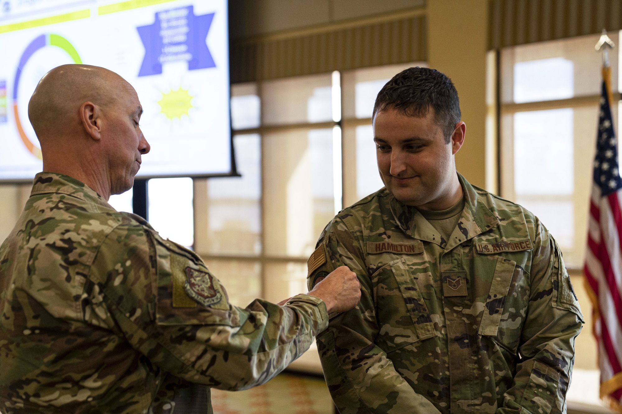 U.S. Air Force Staff Sgt. David Hamilton, 81st Training Support Squadron curriculum developer, is presented the Dragon University Wingman patch by U.S. Air Force Col. William Hunter, 81st Training Wing commander, at Keesler Air Force Base, July 27, 2022. Dragon University offers personal and professional development courses to Airmen, Guardians and civilians stationed at Keesler.