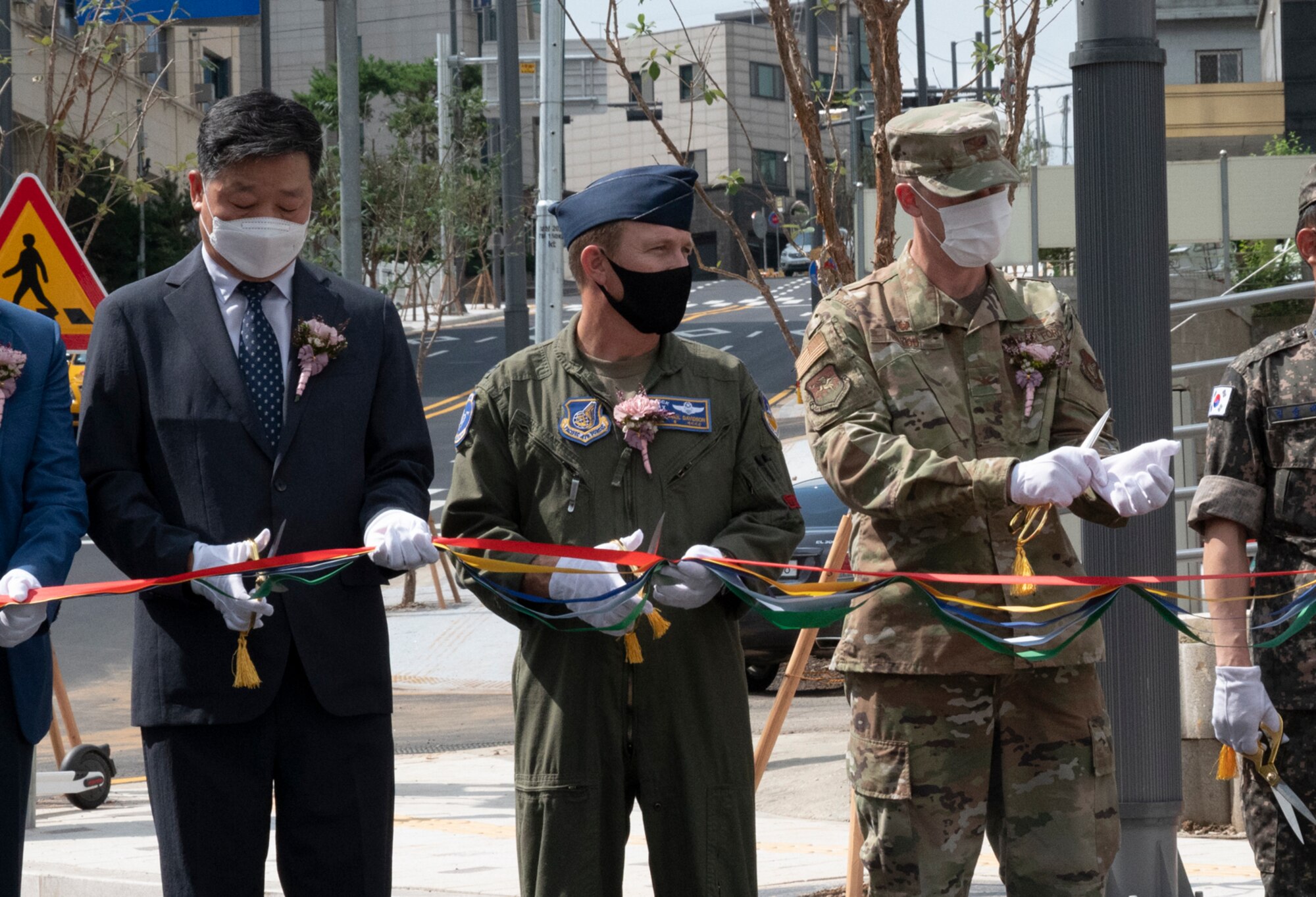 Col. Paul Davidson, 51st Fighter Wing vice commander, and Col. Kyle Grygo, 51st Mission Support Group commander, prepare to cut the ribbon during a ceremony celebrating the newly constructed roundabout outside of Osan Air Base, Republic of Korea, July 25, 2022.