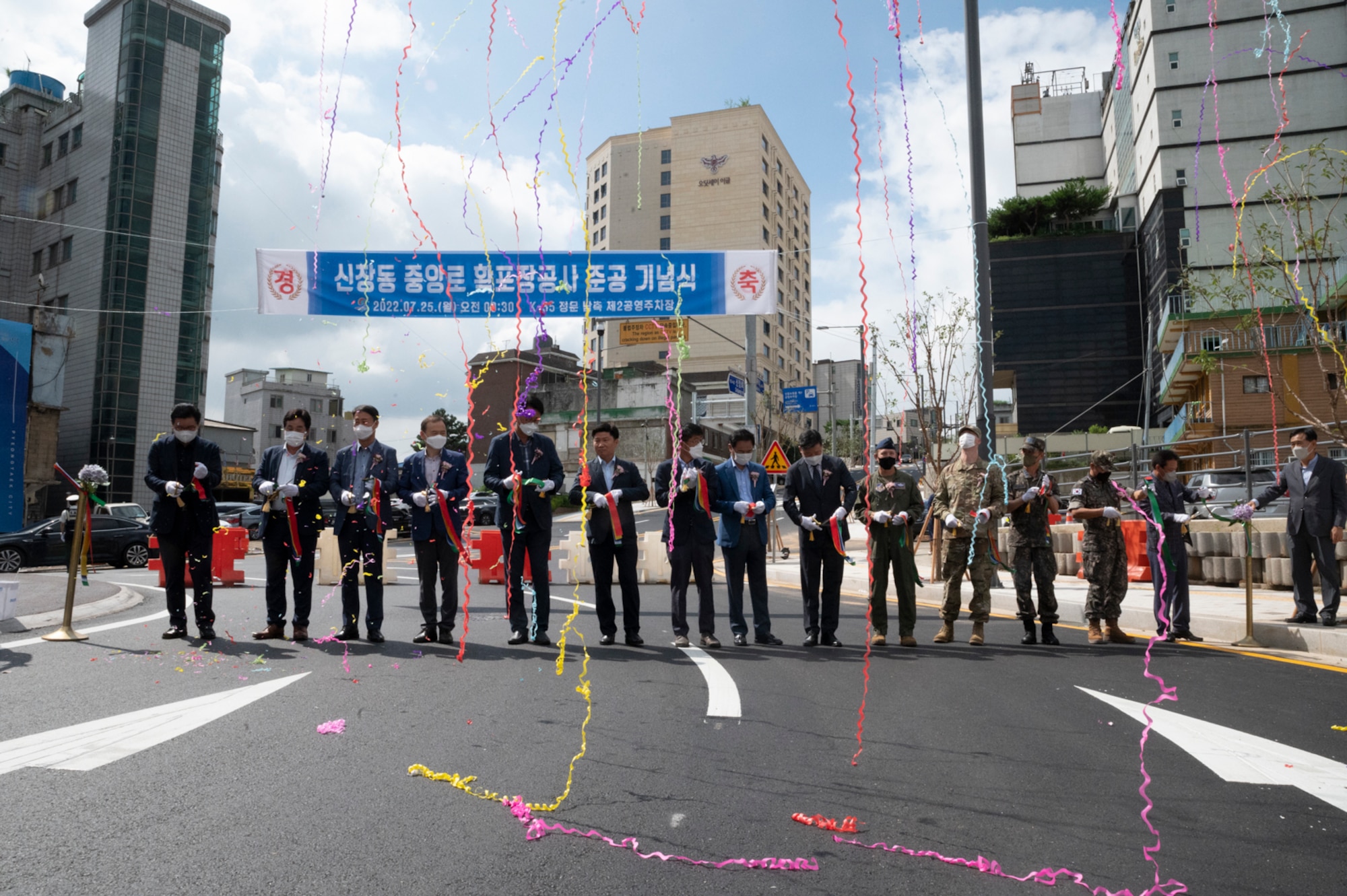 Leaders from the local community cut the ribbon during the ribbon cutting ceremony for the new road outside of Osan Air Base, Republic of Korea, July 25, 2022.