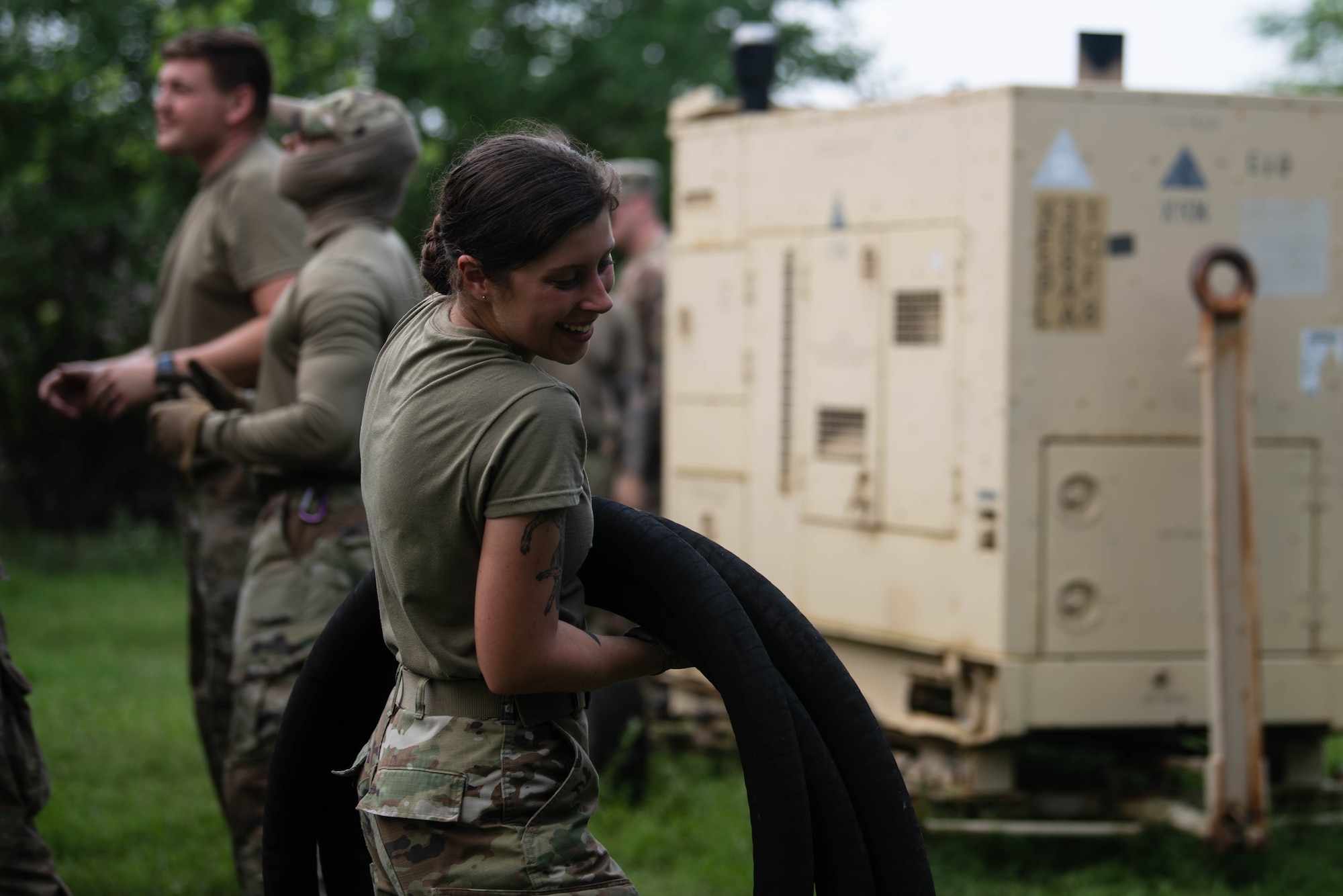 An Airman carries a hose