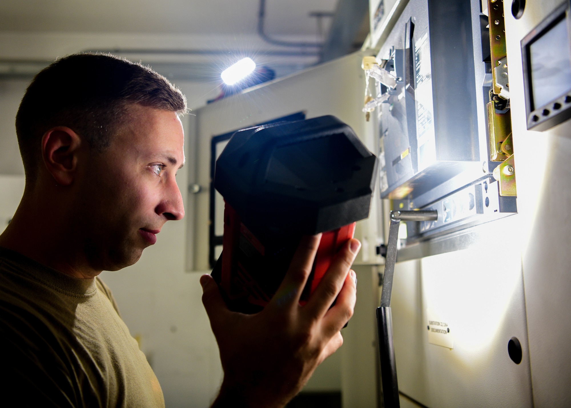 U.S. Air Force Tech. Sgt. Jacob Lanzer, Civil Engineer Maintenance, Inspection and Repair Team craftsman, inspects a low voltage circuit breaker at building 1064 at Aviano Air Base, Italy, June 21, 2022. CEMIRT provides Air Force-wide specialized maintenance, installation and repair support on electrical distribution systems, power production systems, aircraft arresting systems, and heating, ventilating and air conditioning systems during peacetime and emergency response operations. (U.S. Air Force photo by Senior Airman Brooke Moeder)