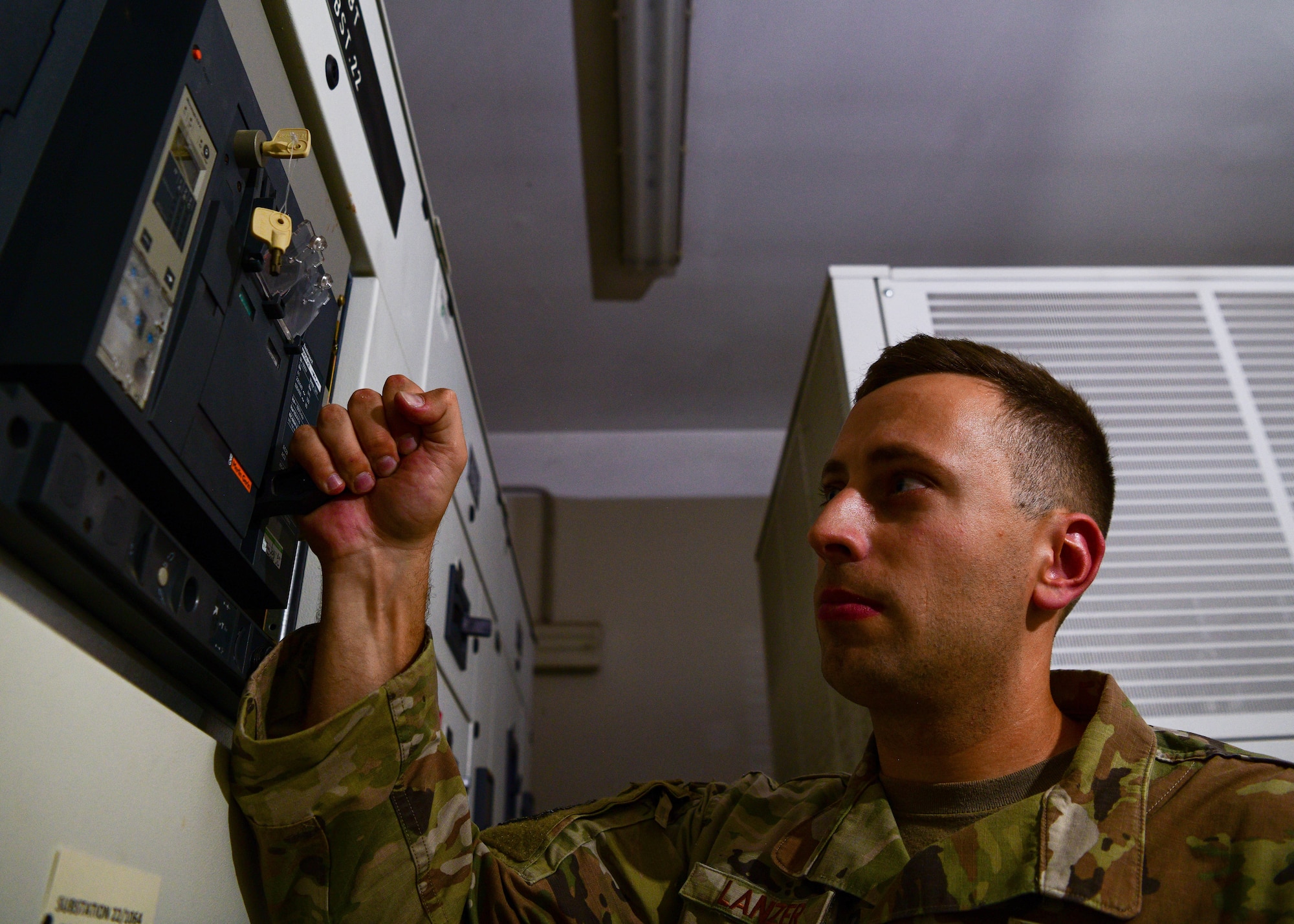 Tech. Sgt. Jacob Lanzer, Civil Engineer Maintenance, Inspection and Repair Team craftsman from Travis Air Force Base, California, exercises a charging handle on a low voltage circuit breaker during routine maintenance at Aviano Air Base, Italy, June 21, 2022. Operating the charging handle charges the spring in the breaker that allows the breaker to operate. (U.S. Air Force photo by Senior Airman Brooke Moeder)