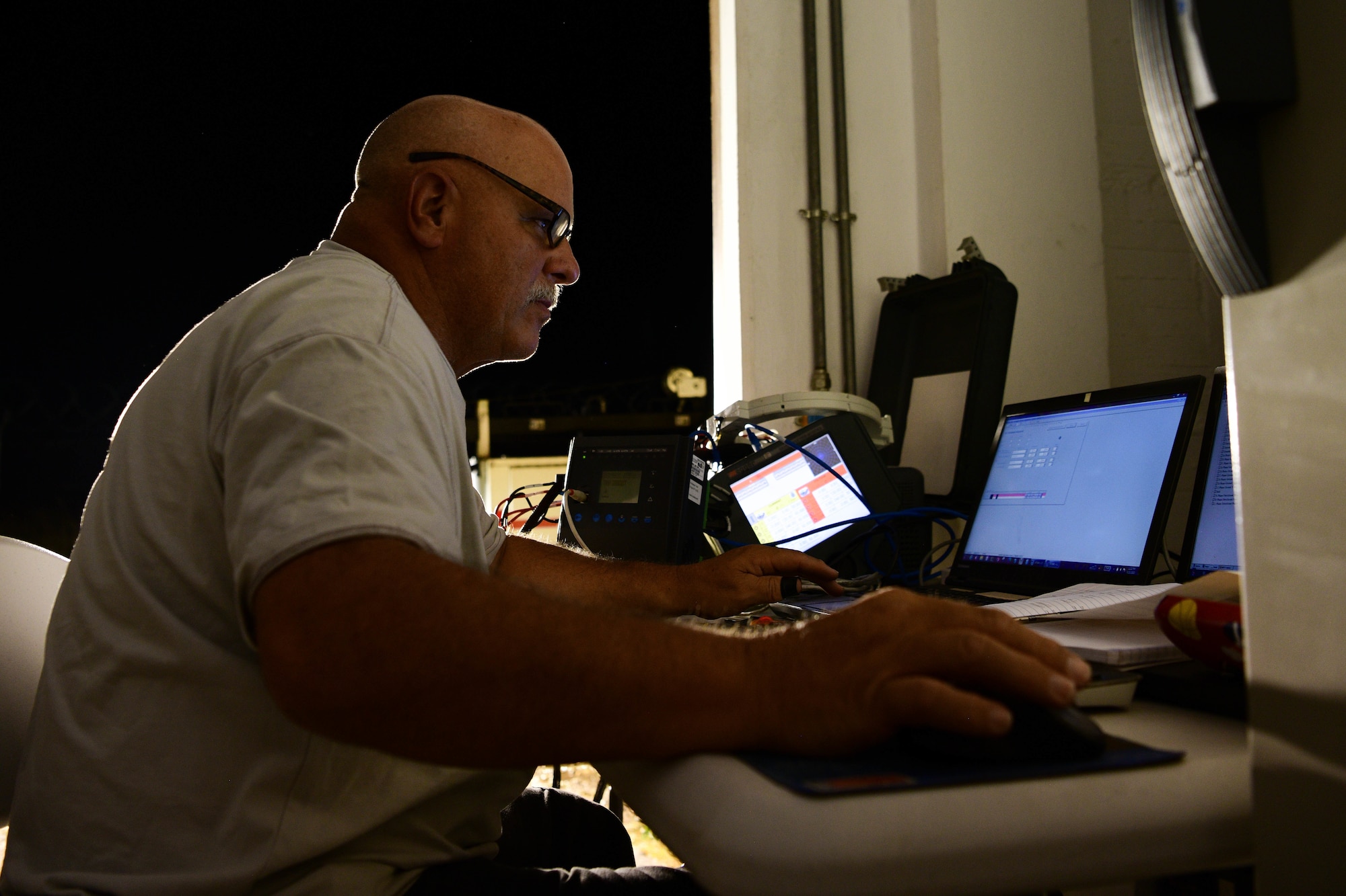 Mr. Richard Willet, Civil Engineer Maintenance, Inspection and Repair Team high voltage electrician from Tyndall Air Force Base, Florida, tests a protective relay during routine maintenance at a substation at Aviano Air Base, Italy, June 21, 2022. The CEMIRT team is testing the parameters that are setup to endure proper operations for the circuits. The relay protects the circuit breaker. (U.S. Air Force photo by Senior Airman Brooke Moeder)