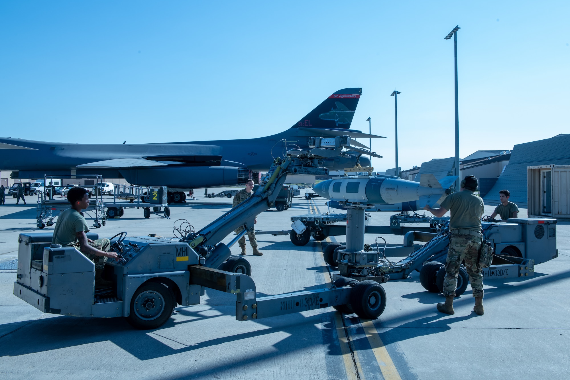 U.S. Air Force Airmen from the 28th Aircraft Maintenance Squadron transfer munitions from one lifting truck to another during a weapons loading competition at Ellsworth Air Force Base, S.D., July 22, 2022.