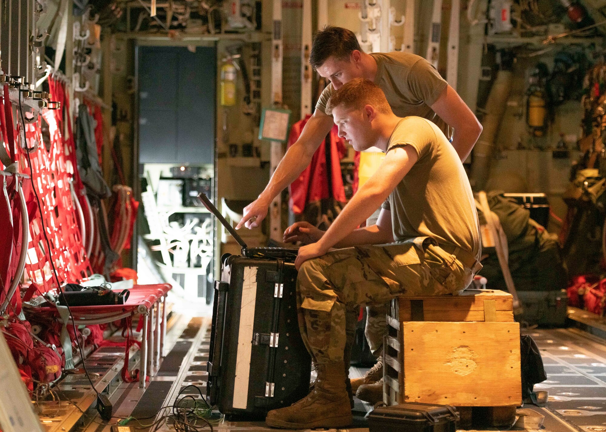 Airman 1st Class Noah Klaus, front, integrated communication, navigation, electronic countermeasure journeyman, and Staff Sgt. Griffen Boll, 374th Aircraft Maintenance Squadron integrated communication, navigation, electronic countermeasure craftsman, checks a radar warning receiver system in a C-130J Super Hercules to ensure aircraft readiness at Yokota Air Base, Japan, July 26, 2022