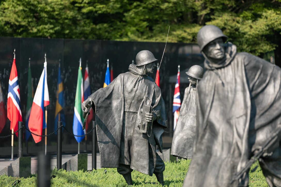 On July 27, 2022, a Marine Band trumpeter rendered "Taps" during a wreath laying ceremony for the dedication of the Korean War Veterans Memorial Wall of Remembrance. Shown is one of the memorial's  statues of a U.S. troop. (U.S. Marine Corps photo by Staff Sgt. Chase Baran/released)