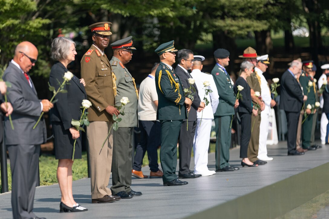 On July 27, 2022, a Marine Band trumpeter rendered "Taps" during a wreath laying ceremony for the dedication of the Korean War Veterans Memorial Wall of Remembrance. Representatives from each ally country in the Korean War prepare to lay white roses over the names of their country on the memorial. (U.S. Marine Corps photo by Staff Sgt. Chase Baran/released)
