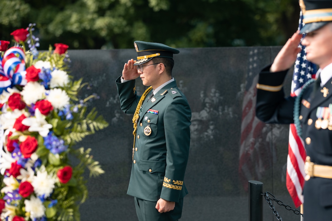 On July 27, 2022, a Marine Band trumpeter rendered "Taps" during a wreath laying ceremony for the dedication of the Korean War Veterans Memorial Wall of Remembrance. A U.S. and South Korean soldier render a salute during the ceremony.  (U.S. Marine Corps photo by Staff Sgt. Chase Baran/released)
