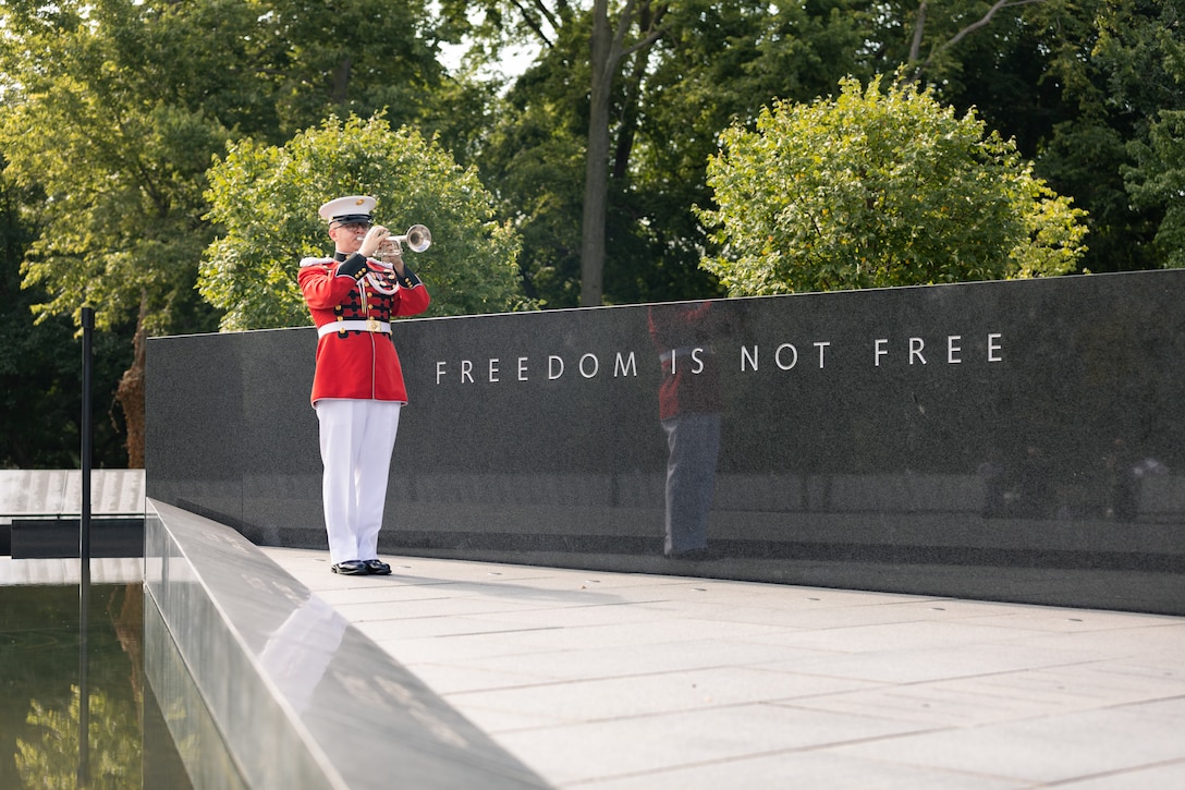 On July 27, 2022, Marine Band trumpeter Staff Sgt. Tyler Lindsay rendered "Taps" during a wreath laying ceremony for the dedication of the Korean War Veterans Memorial Wall of Remembrance. (U.S. Marine Corps photo by Staff Sgt. Chase Baran/released)