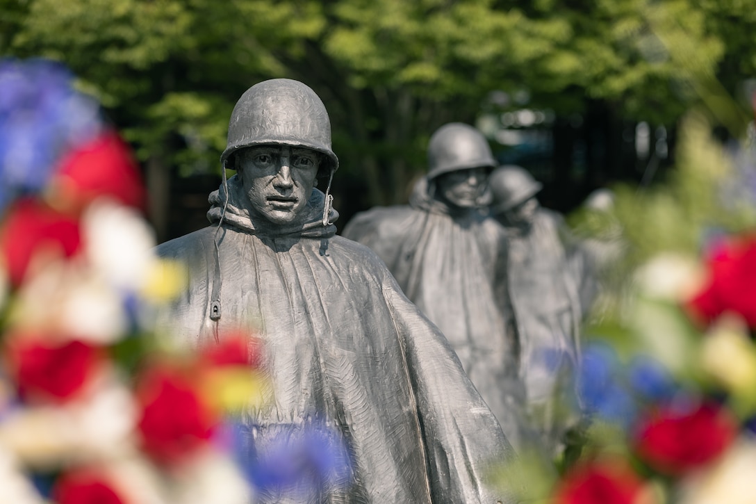 On July 27, 2022, a Marine Band trumpeter rendered "Taps" during a wreath laying ceremony for the dedication of the Korean War Veterans Memorial Wall of Remembrance. Statues of Korean War troops peer from behind the wreaths laid during the ceremony. (U.S. Marine Corps photo by Staff Sgt. Chase Baran/released)
