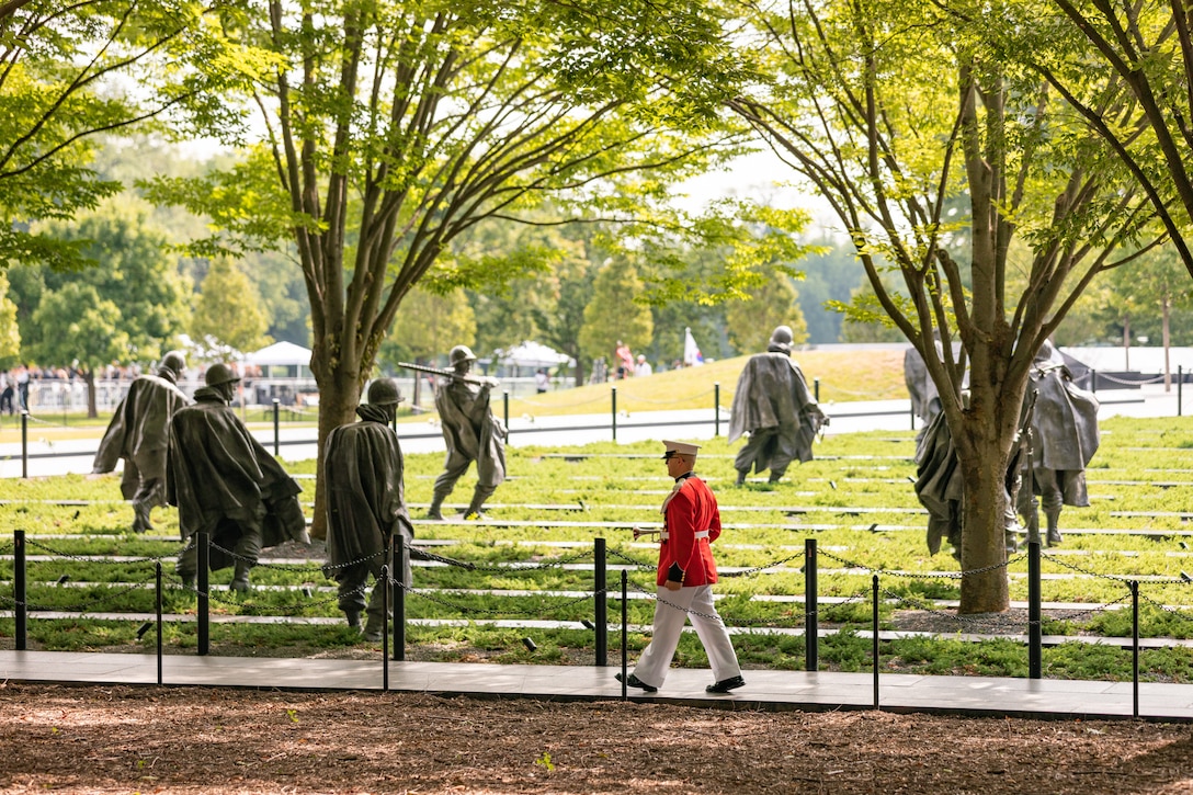 On July 27, 2022, a Marine Band trumpeter rendered "Taps" during a wreath laying ceremony for the dedication of the Korean War Veterans Memorial Wall of Remembrance. Trumpeter Staff Sgt. Tyler Lindsay marches by the statues of Korean War soldiers. (U.S. Marine Corps photo by Staff Sgt. Chase Baran/released)