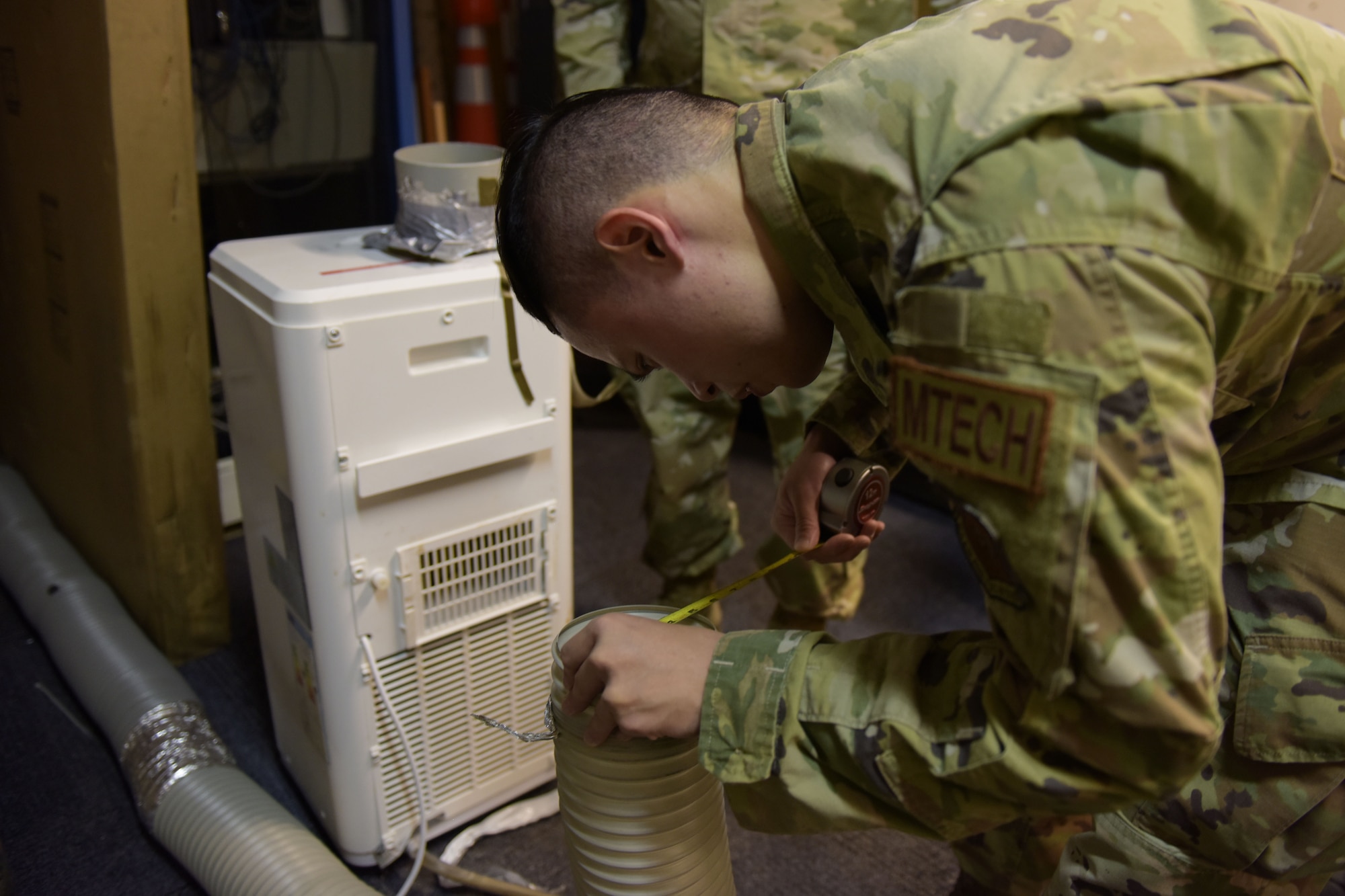 Man measures air conditioning tube with a tape measure