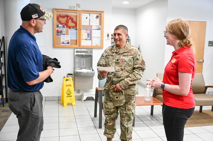 Lt. Col. Martin Martinez, Air Force Operational Test and Evaluation Center, receives a donation from Wish for Our Heroes representatives Tim Neal and Raylee Hawks