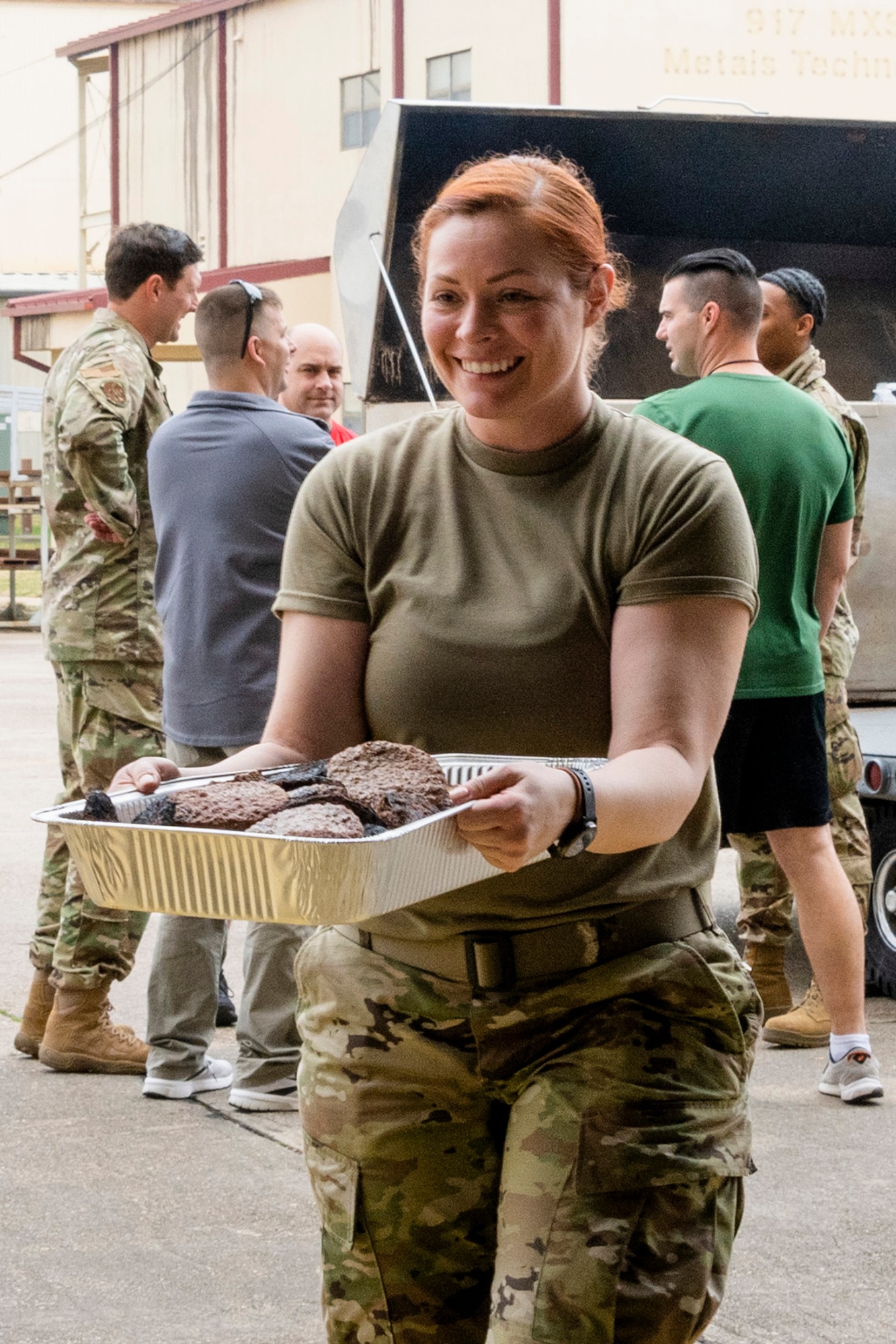 Airman carrying a tray of hamburgers