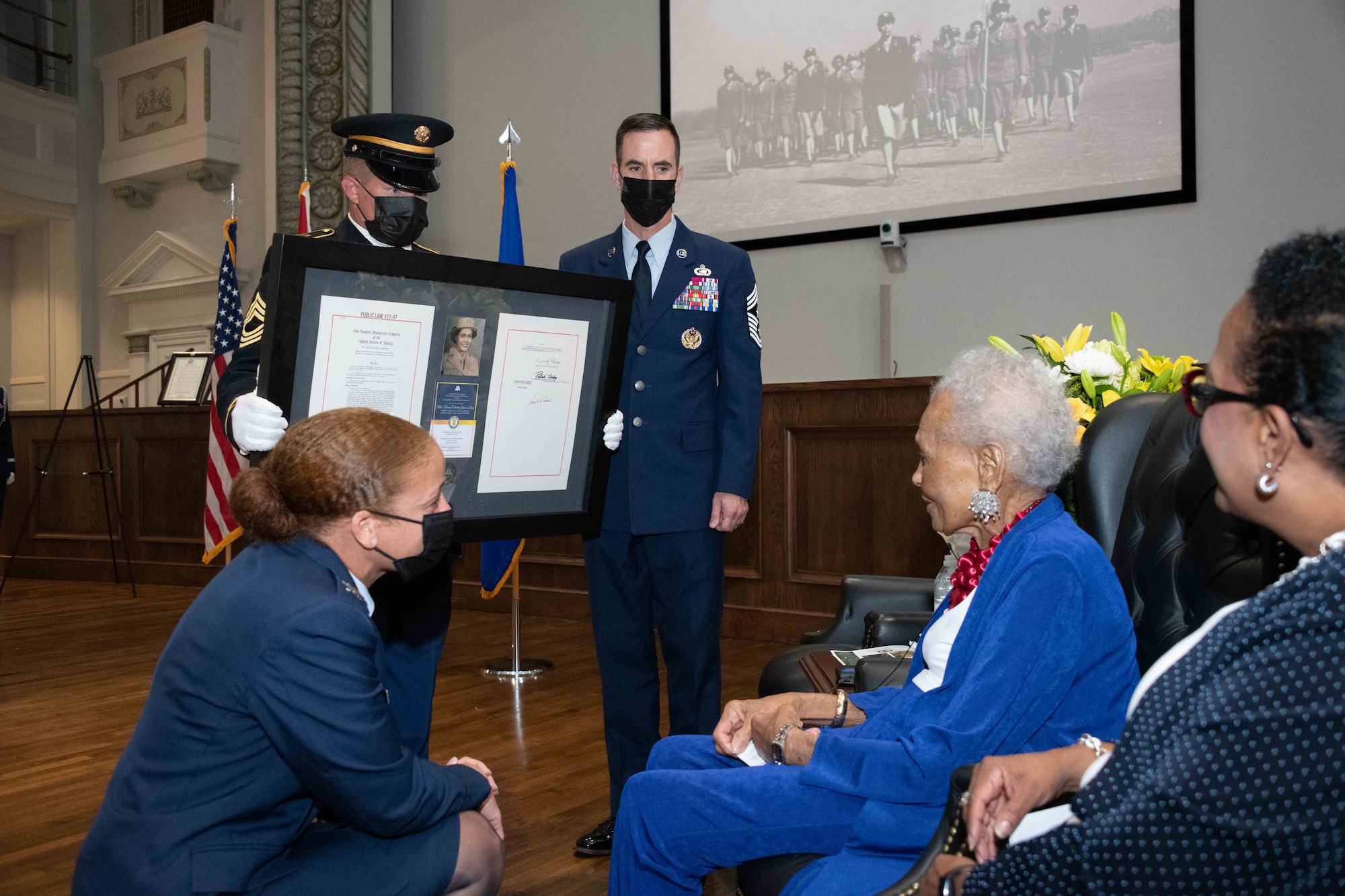 Col. Eries Mentzer, Commander, 42d Air Base Wing, Chief Master Sgt. Lee Hoover, Command Chief Master Sergeant, 42d ABW, and an Alabama National Guard Honor Guardsman present the framed citation of the Congressional Medal of Honor to Private Romay Catherine Johnson Davis at Montgomery City Hall, Jul. 26, 2022.