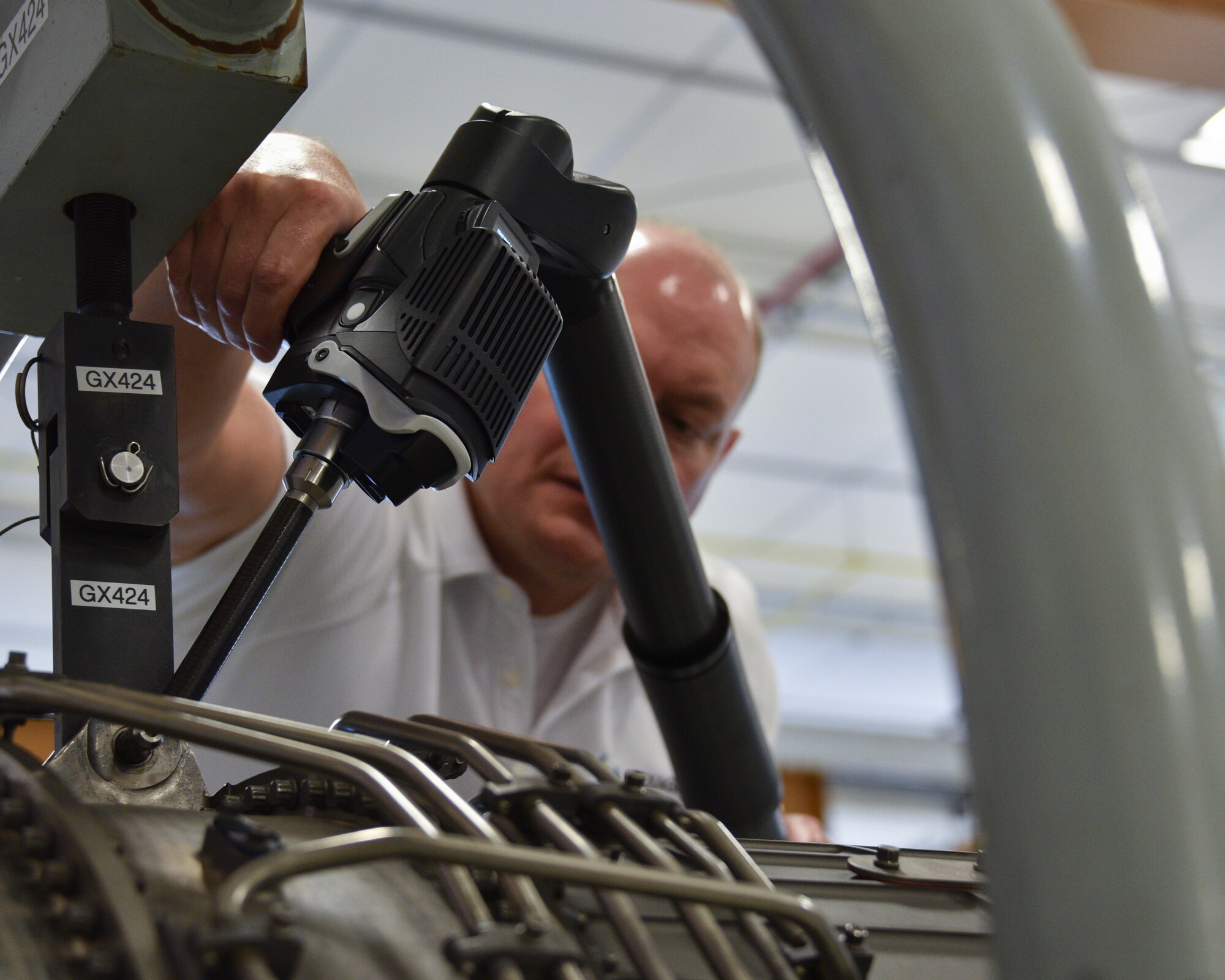 Photo of an aircraft engineer taking measurements of an aircraft engine