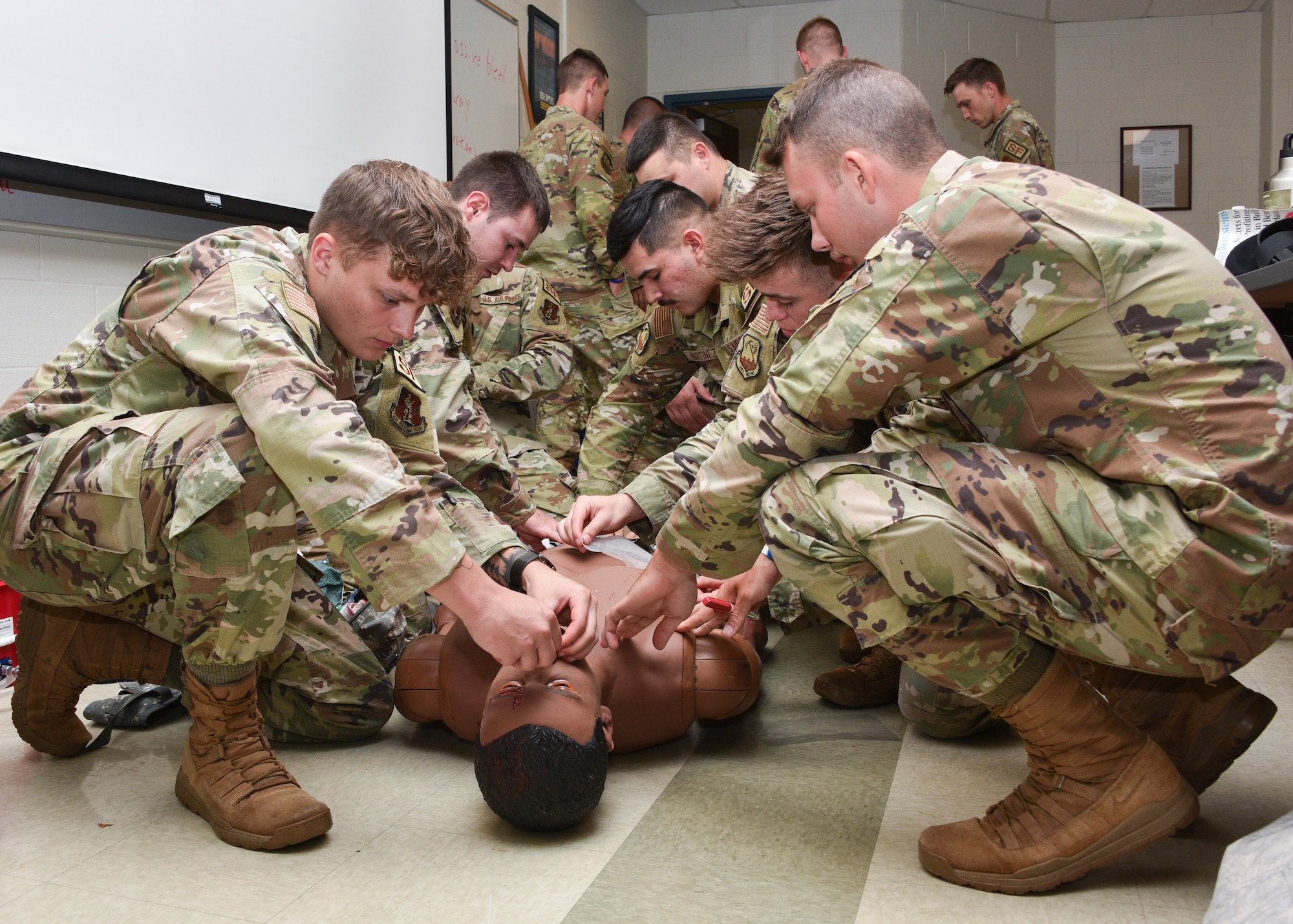 Photo of airmen and soldiers practicing lifesaving techniques on a manikin