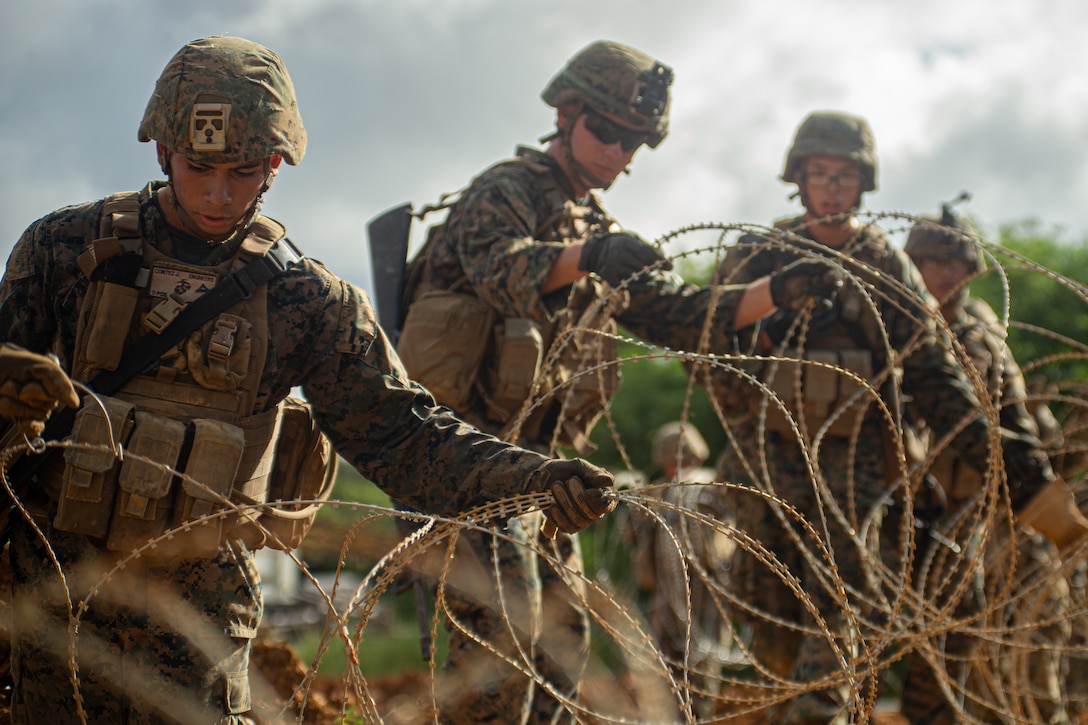 U.S. Marines with 3rd Landing Support Battalion, Combat Logistics Regiment 3, 3rd Marine Logistics Group set concertina wire along their defensive position's perimeter, Urban Terrain Town, Eastern Training Area, Okinawa, Japan, July 21, 2022. 3rd MLG, based out of Okinawa, Japan, is a forward-deployed combat unit that serves as III MEF’s comprehensive logistics and combat service support backbone for operations throughout the Indo-Pacific area of responsibility.