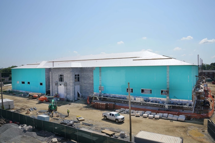 A large school building halfway constructed planted in the middle of a construction site.