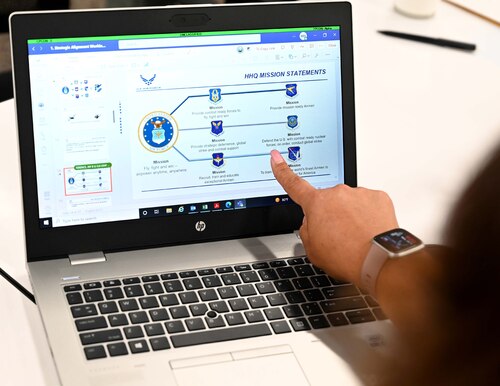 a woman points to a computer screen