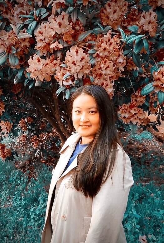 Photo of woman named Mary Hesser in front of a flowering tree at Spanaway Park, Spanaway, Washington state.