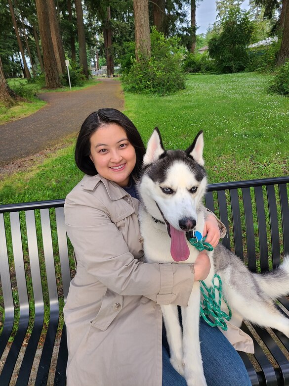 Photo of woman named Mary Hesser sitting with her dog on a park bench.