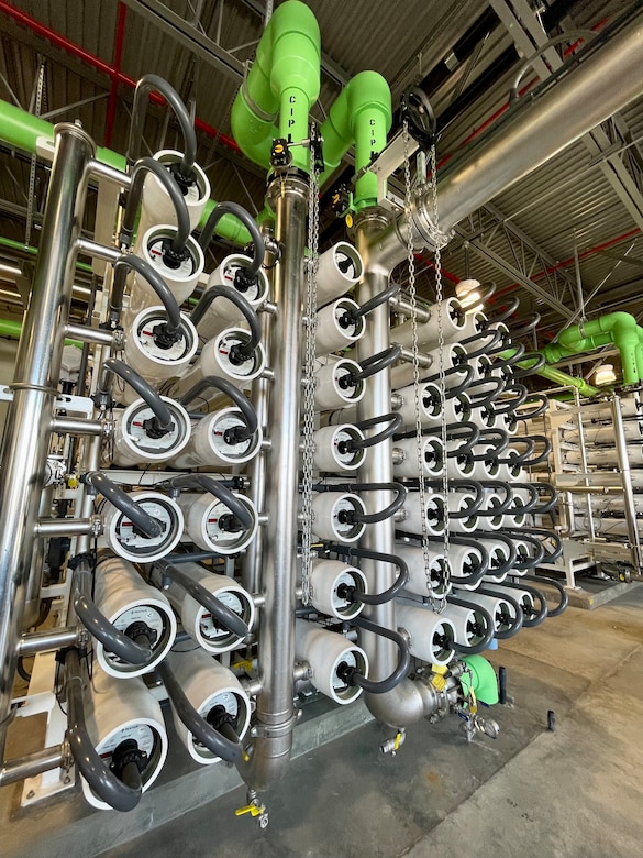 Pictured is an array of pressurized tubes — each containing a series of filters with microscopic pores through which water molecules are able to pass — that separate and remove salts and other impurities.
