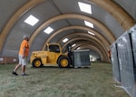 A man and a tractor inside a large, inflatable warehouse.