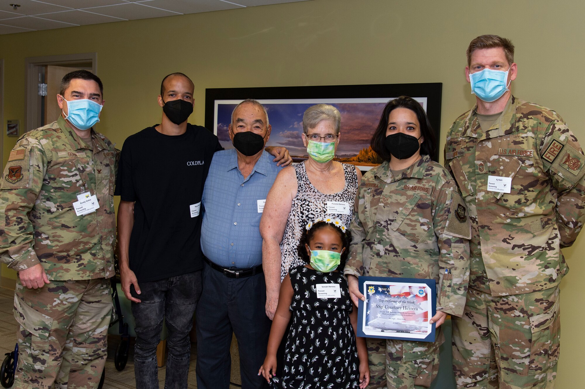 Col. Rusty Gohn, left, 436th Airlift Wing vice commander, poses for a photo with Staff Sgt. Courtney Herrera, second from right, 436th Medical Group senior enlisted leader executive officer, along with Herrera's family on Dover Air Force Base, Delaware, July 26, 2022. Gohn presented Herrera with a certificate and coin for being recognized as the week's Top Performer. Accompanying Gohn was Chief Master Sgt. Andrew Kehl, right, 436th Civil Engineer Squadron fire chief. (U.S. Air Force photo by Roland Balik)