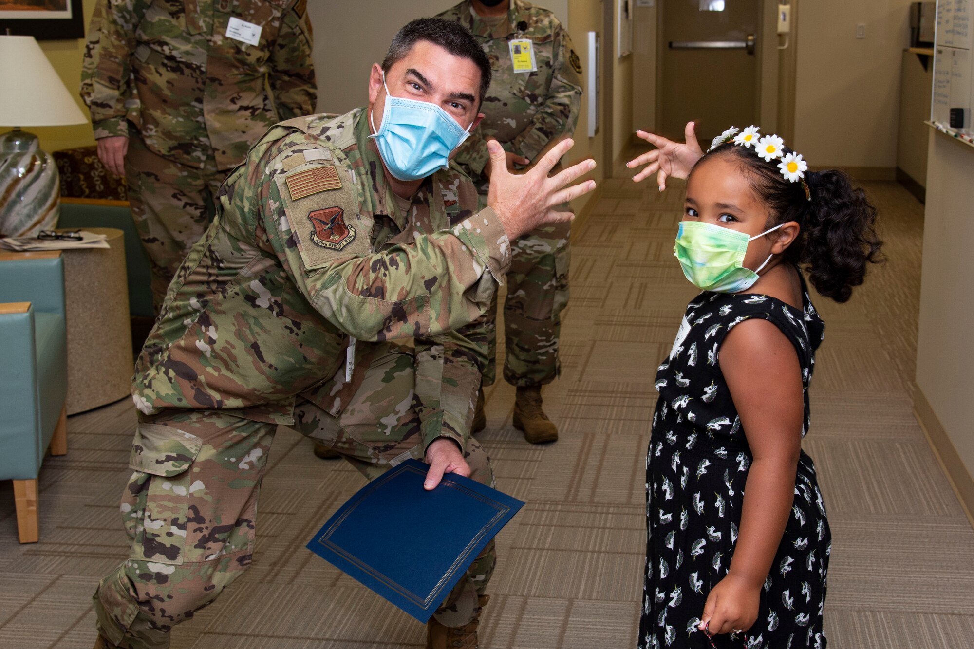 Col. Rusty Gohn, left, 436th Airlift Wing vice commander, poses for a photo with Veniah Herrera, right, daughter of Staff Sgt. Courtney Herrera, 436th Medical Group senior enlisted leader executive officer, on Dover Air Force Base, Delaware, July 26, 2022. Gohn presented Staff Sgt. Herrera with a certificate and coin for being recognized as the week’s Top Performer for her outstanding work. (U.S. Air Force photo by Roland Balik)