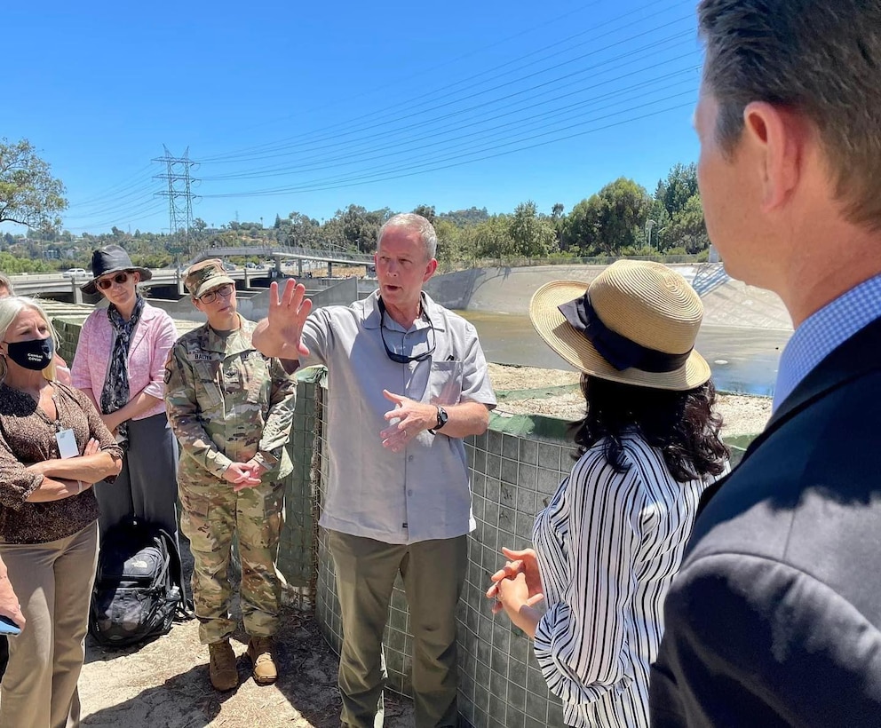 Eric Bush, chief of the Planning and Policy Division for Headquarters, U.S. Army Corps of Engineers, center, asks questions during a July 6 briefing with Priyanka Wadhawan, Los Angeles System Restoration project manager with the Corps’ LA District, second from right, about the LA River during a stop in Los Feliz, several miles from downtown LA. Topics included ecosystem restoration, operations and maintenance, and divestiture. The accompanying group included leaders and subject-matter experts from the Corps’ LA District, USACE South Pacific Division, and Headquarters. Left of center is Col. Julie Balten, LA District commander; and at right is David Van Dorpe, district deputy for project management.