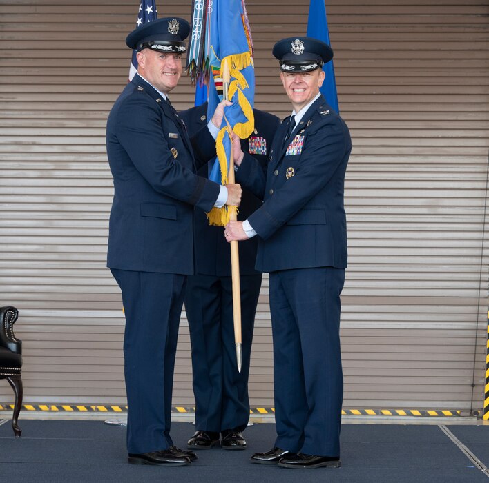 U.S. Air Force Maj. Gen. Kenneth Bibb, left, 18th Air Force commander, passes the guidon to Col. Derek Salmi, 60th Air Mobility Wing commander, during a change of command ceremony at Travis Air Force Base, California, July 27, 2022. Bibb was the presiding officer for the change of command ceremony. (U.S. Air Force photo by Heide Couch)