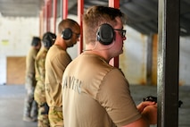 U.S. Airmen from the 628th Security Forces squadron prepare to fire during the Excellence in Competition Pistol Shoot