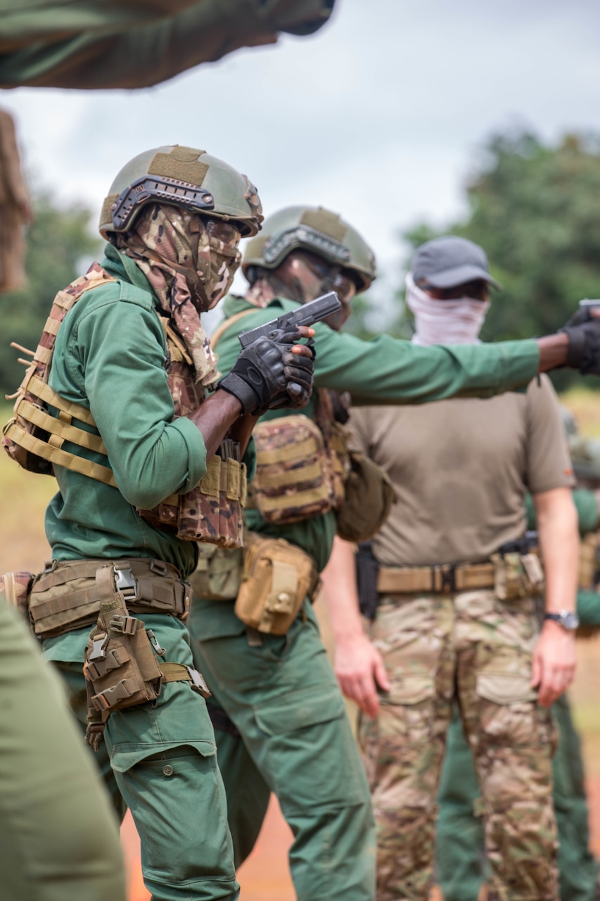 Masked, helmeted soldiers practice marksmanship.